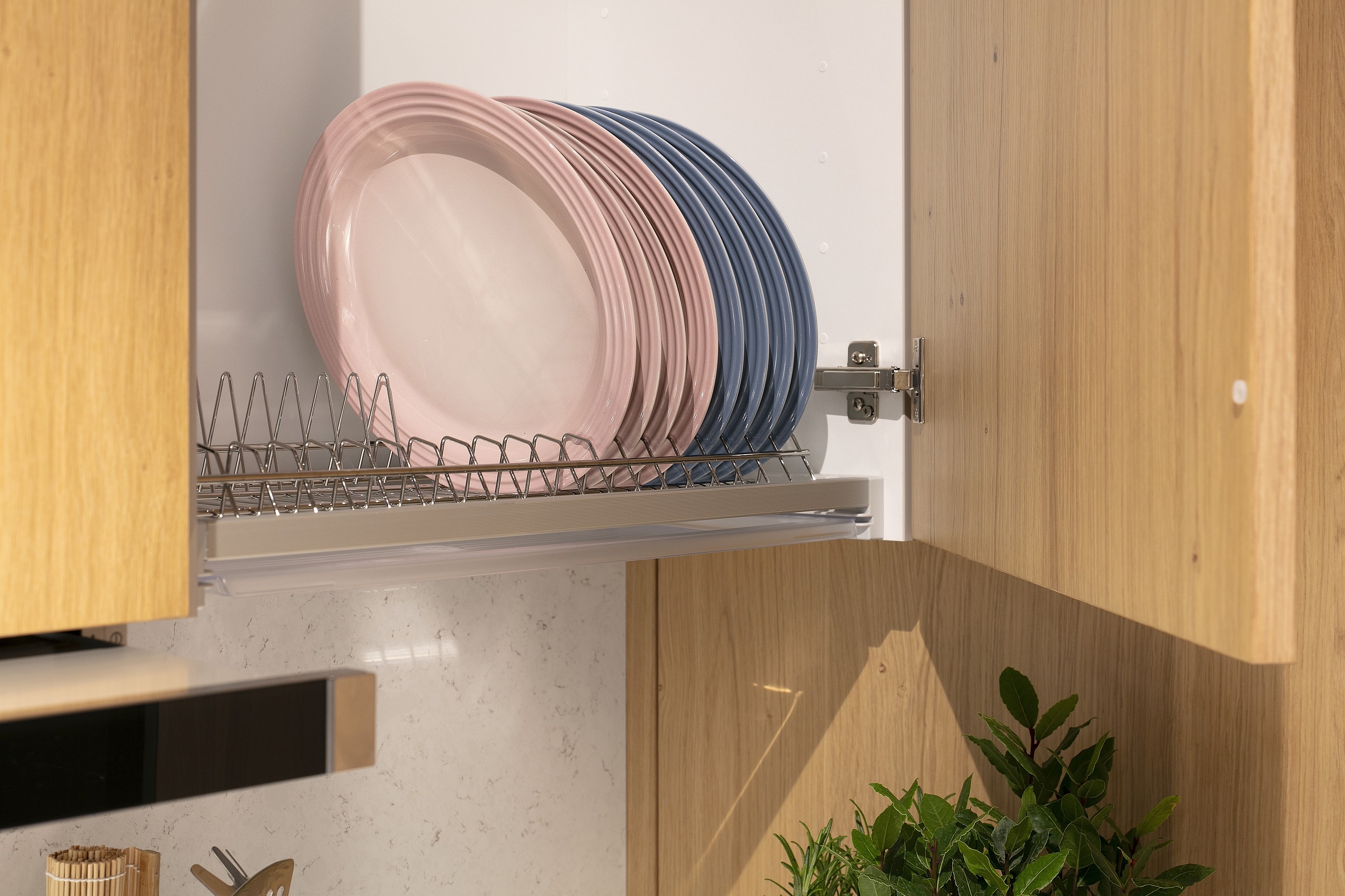 Geöffneter Küchen-Hängeschrank mit Abtropfgestell und Tellern darauf